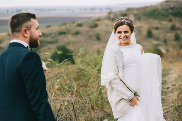 portrait of a girl and couples looking for a wedding dress, a pink dress flying with a wreath of flowers on her head on a background tsvetu chicago garden and the blue sky, and they hug and pose