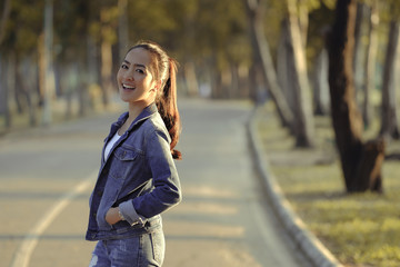 Portrait of happy smile girl in jeans dress stand outdoor with beautiful sunset