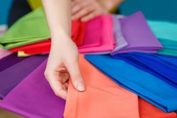 samples of colorful fabric in hands 