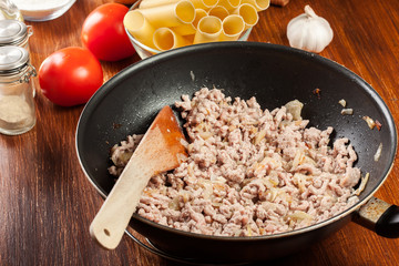 Minced meat fried with onions and garlic in the frying pan. Preparation cannelloni