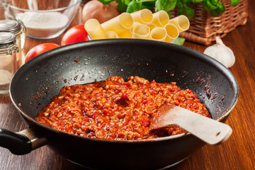 Minced meat fried in tomato sauce in the frying pan. Preparation cannelloni