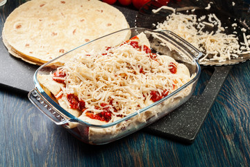 Traditional mexican enchiladas with chicken meat, spicy tomato sauce and cheese in heat resistant dish