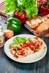 Traditional mexican enchiladas with chicken meat, spicy tomato sauce and cheese on a plate