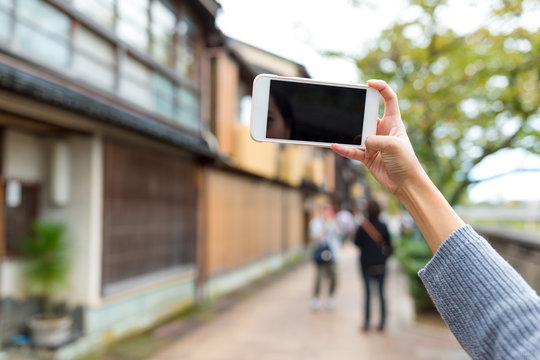 Woman taking photo with cellphone in kanazawa
