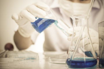 Scientists are experimenting with chemicals. A scientific beaker vitro camera microscope can be used in scientific articles or books about chemistry, scientists are Asian women .