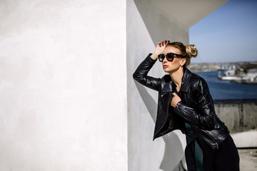 Close up fashion ;luxury portrait of stunning sexy woman, full perfect lips and face, sunny day sunglasses and leather jacket, big trendy earnings, grunge urban style.