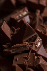 Milk chocolate. Milk chocolate pieces on a wooden background