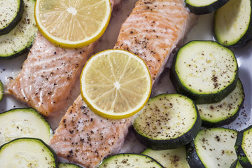 Tasty slices of stewed salmon with lemon and zucchini