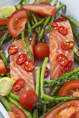 Two pieces of salmon with green asparagus, tomato and red pepper