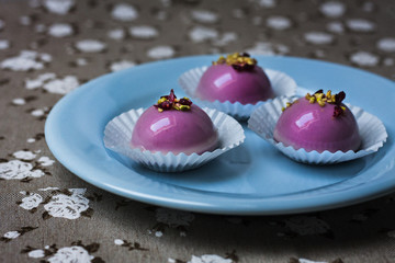 Cherry red pink mini mousse on a blue plate