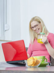 Young woman working at home, using laptop.