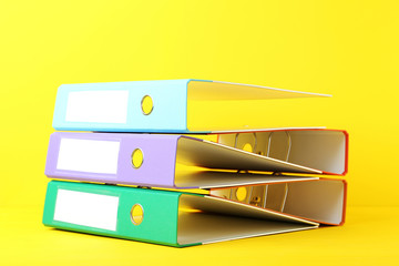 Colorful office folders on yellow background