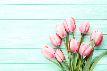 Pink tulips on green wooden table