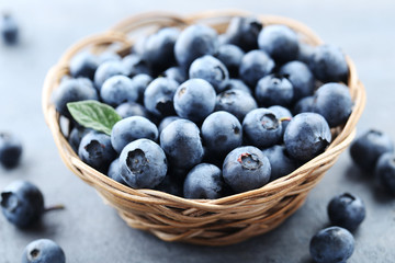 Ripe and tasty blueberries on grey wooden table