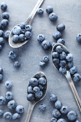 Ripe and tasty blueberries on grey wooden table