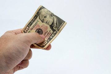 A close up photo of a Caucasian male hand holding a 10 dollar USA note 