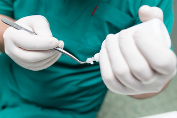 A dentist prepares an implant in the clinic
