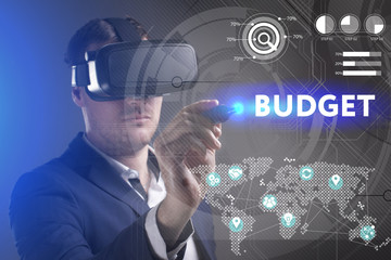 Business, Technology, Internet and network concept. Young businessman working in virtual reality glasses sees the inscription: Budget