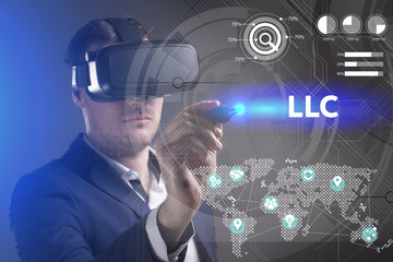 Business, Technology, Internet and network concept. Young businessman working in virtual reality glasses sees the inscription: LLC