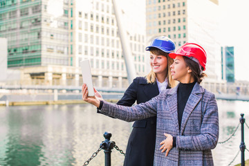 Happy young architects do selfie-photo on the tablet outdoors