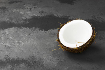 Half of ripe coconut on a dark background. Top view, copy space. Food background