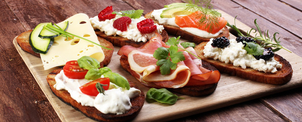 Bread Brushetta or authentic traditional spanish tapas set for lunch table. Sharing antipasti on party or summer picnic time over wooden rustic background.