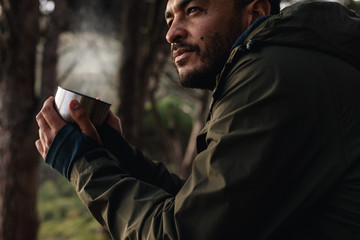 Hiker relaxing and having coffee outdoors