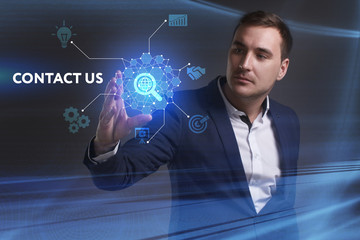 Business, Technology, Internet and network concept. Young businessman working on a virtual screen of the future and sees the inscription: Contact us