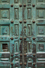 Closeup of blue turquoise old textured antique door with old metal elements and keyhole. Vertical.