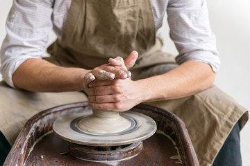 Hands working on pottery wheel