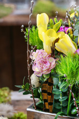 Easter floral decoration with yellow freesia flowers and pink carnation.