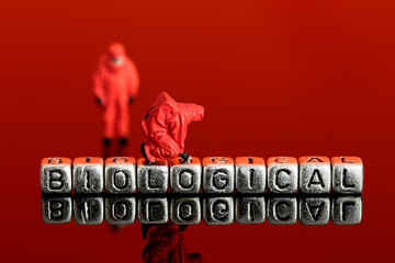 Naklejka premium Miniature scale model team in chemical suits with the word biological on beads
