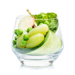 Pieces of apple, grapes and cucumber in a glass