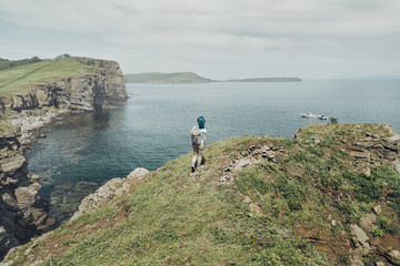 Female traveler walking on high coast