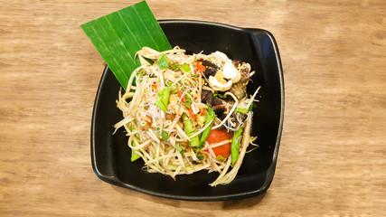 papaya salad with vermicelli and salted crab on black dish