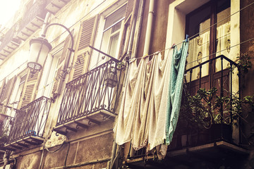 View on beautiful old european street with old wooden windows, balcony and washed laundry. Toning. Retro. Italy, Sardinia.