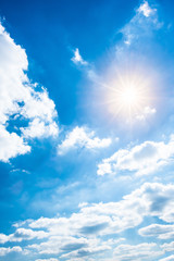 Fototapeta na wymiar Blauer Himmel mit Wolken und Sonne als Hintergrund
