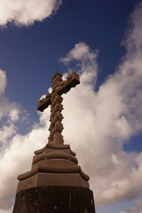 Cross carved in stone with sky in background