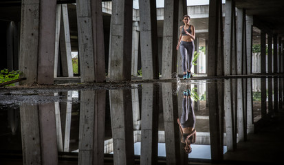 Young woman runner is seen running in an abandoned hall. Running is a good exercise for cardio vascular system and general health and weight control.