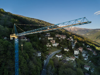 Aerial view of construction site crane in alpine valley in Switzerland