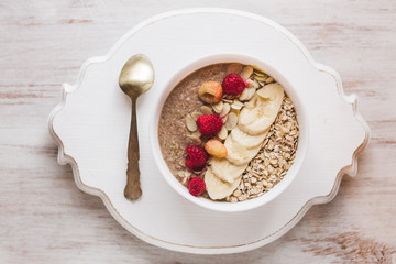 Healthy breakfast with granola, berries, nuts and smoothie. Isolated on white textured wooden background