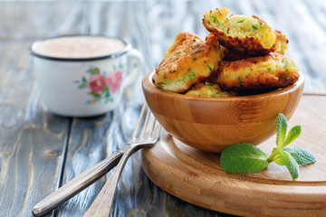 Fritters of zucchini in a wooden bowl.