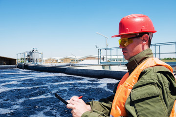 An engineer controlling a quality of water ,aerated activated sludge tank at a waste water...