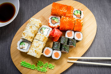Set sushi rolls, soy sauce and chopsticks on a grey background. Top view. Flat lay. Japanese traditional food
