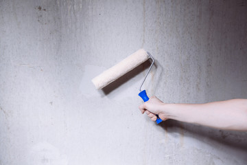 Close-up of mans hands using paint roller while working