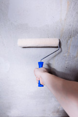 Close-up of mans hands using paint roller while working