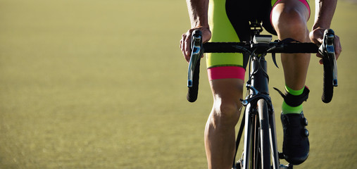 Cyclist man with hands on handbar of racing bike, detail