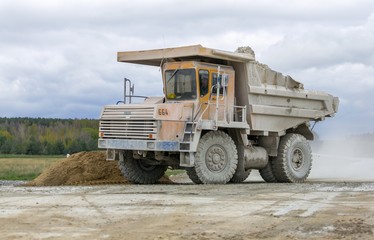 Obraz premium Large-yellow quarry dump trucks produce transportation of minerals