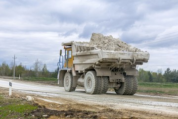 Large-yellow quarry dump trucks produce transportation of minerals