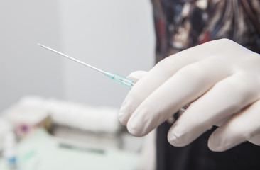 Professional holding the needle cannula on hand for piercing